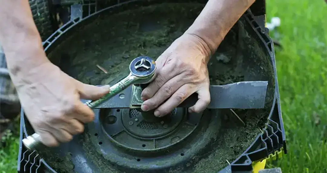 Person maintaining lawn mower